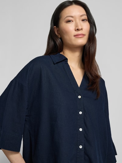 Frauenmodel trägt Boxy Fit Bluse mit V-Ausschnitt Modell 'Lava' von FREE/QUENT aus Leinen-Viskose-Mix, dunkelblau, Knopfleiste, Nahaufnahme Oberkörper.