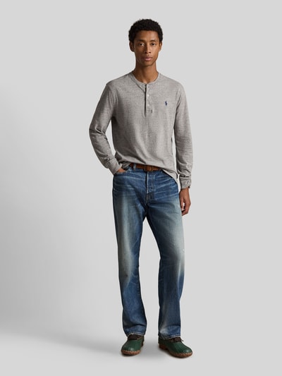 Männermodel trägt Regular Fit Langarmshirt aus reiner Baumwolle von Polo Ralph Lauren in Grau, kombiniert mit blauer Jeans, Ganzkörperansicht von vorne, Herren Langarmshirt von Polo Ralph Lauren.