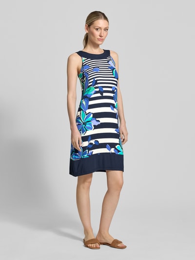 Frauenmodel trägt Knielanges Kleid aus Viskose-Mix mit Rundhalsausschnitt von Betty Barclay, blau-weiß gestreift mit floralen Mustern, Straight Fit, Ganzkörperansicht von vorne.