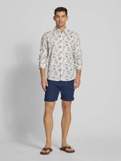 Męski model nosi Leinenshorts mit Bindegürtel und Gesäßtaschen von MCNEAL, granatowy len, krój straight fit, przednie wpuszczane kieszenie, zapięcie na guzik i zamek błyskawiczny, wiązany pasek, kieszenie z tyłu z wypustką i guzikiem, długość wewnętrzna nogawki w rozmiarze M: 16 cm, szerokość w rozmiarze M: 45 cm, wyhaftowane logo na tyle, zakładka na nogawkach, Ganzkörperansicht von vorne