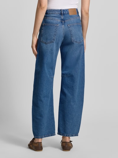 Frauenmodel trägt Barrel Fit Jeans mit Eingrifftaschen Modell 'ALMA' von Topshop in klassischem Blau aus reiner Baumwolle, Ganzkörperansicht Rückansicht, Damen Jeans, Bundweite bei Größe 26/32: 34 cm, Innenbeinlänge 75 cm.