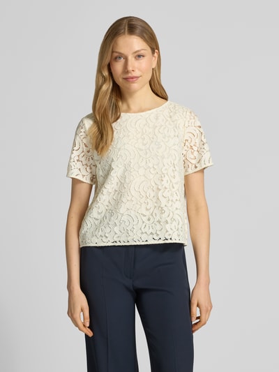 Frauenmodel trägt Regular Fit Bluse mit Baumwoll-Anteil von s.Oliver BLACK LABEL, jednolity kolor, krój regular fit, kwiatowy wzór z koronki, krój krótki, półprzezroczyste detale z koronki, dekolt w łódkę, zapięcie na 1 guzik, krótki rękaw, jasny kremowy kolor, gładka struktura, Ganzkörperansicht von vorne.