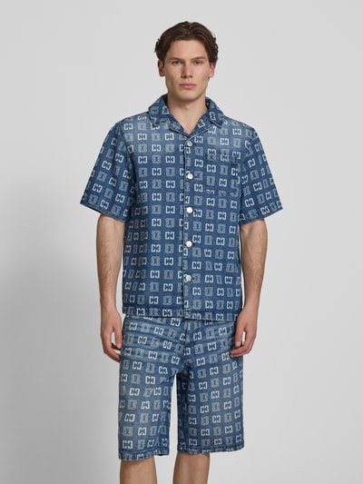 Männermodel trägt Relaxed Fit Freizeithemd in Denim-Optik mit Allover-Logo-Print von COLUCCI aus reiner Baumwolle, Ganzkörperansicht von vorne.
