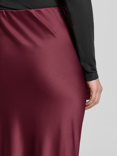 Männermodel trägt Ausgestellter Maxi-Rock mit elastischem Bund Modell 'MERLE' von VERO MODA in dunklem Rot mit glatter Textur, Nahaufnahme Oberkörper, Damen Maxi-Rock