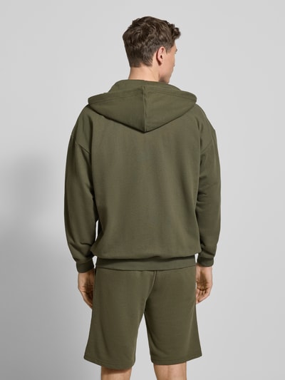 Männermodel trägt Relaxed Fit Sweatjacke aus katoenmix van Tommy Hilfiger, look: effen, met capuchon en kangoeroezak, geribde rompzoom, ganzkörperansicht rückansicht.