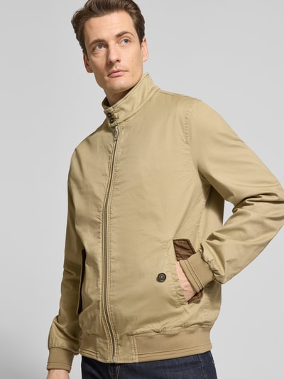 Męski model trägt Jacke mit Stehkragen und Pattentaschen von Christian Berg Men, Mieszanka bawełny i elastanu, krój regular fit, zamek błyskawiczny, kieszenie z patką, długość tyłu w rozmiarze M: 32 cm, szerokość ramion w rozmiarze M: 41 cm, szerokość klatki piersiowej w rozmiarze M: 55 cm, długość rękawów w rozmiarze M: 67 cm, beż, gładki materiał, Ganzkörperansicht von vorne.