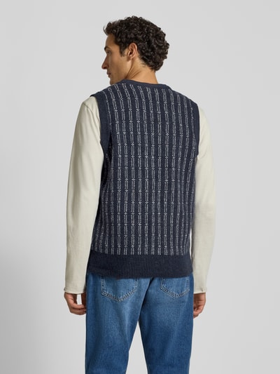 Männermodel trägt Strickweste mit V-Ausschnitt und Knopfleiste von Lindbergh in Dunkelblau mit weißem Muster, Regular Fit, Rückansicht. Material-Mix mit Baumwoll-Anteil, Rückenlänge bei Größe S 64 cm, Schulterbreite 43 cm, Brustweite 50 cm.