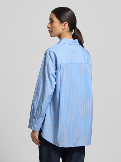Vrouwenmodel draagt 'Hemdbluse mit Knopfleiste' van Windsor in lichtblauw met witte strepen, pure katoen, loose fit, rugaanzicht.