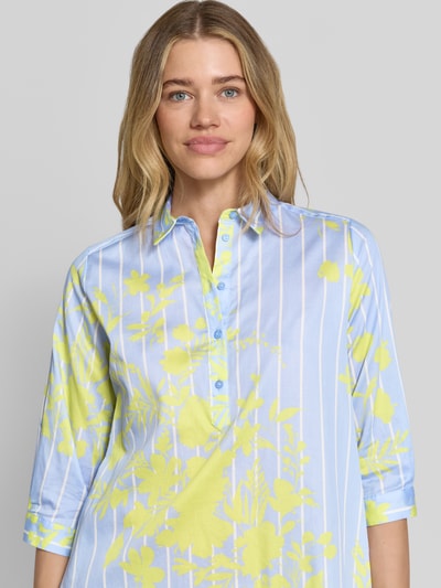 Frauenmodel trägt Knielanges Hemdblusenkleid mit kurzer Knopfleiste von Milano Italy aus Reine Baumwolle mit Gerader-Schnitt, Hemdblusenkragen, 1/2-Arm, Muster in Gelb und Blau, Nahaufnahme Oberkörper.