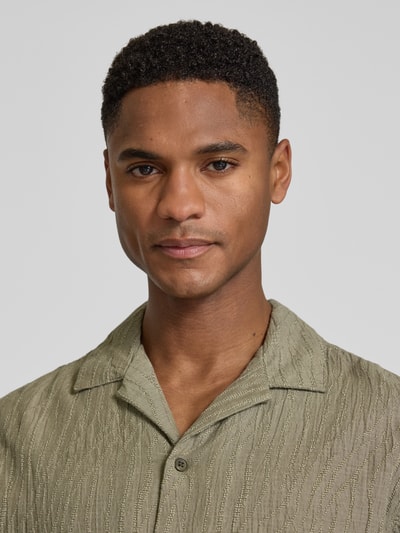 Männermodel trägt Regular Fit Freizeithemd mit Reverskragen von Jack & Jones Premium aus Baumwoll-Elasthan-Mix, Nahaufnahme Oberkörper.