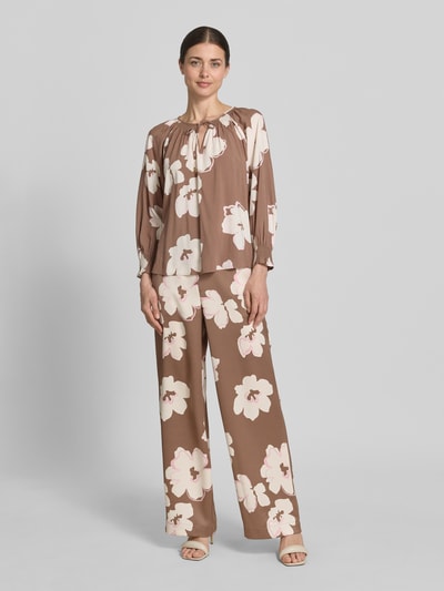 Frauenmodel trägt Loose Fit Satinhose mit Allover-Muster von s.Oliver BLACK LABEL, floral-abstraktes Design in Braun, Ganzkörperansicht von vorne.