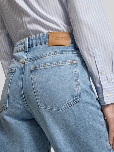 Mężczyzna nosi Wide Leg Jeans im 5-Pocket-Design od Gant, jasnoniebieski denim, bawełniany mix, krój straight fit, detal skóry na pasku, Szerokość w rozmiarze 27: 38 cm, długość wewnętrzna nogawki 79 cm, zdjęcie z tyłu zbliżenie na biodra.