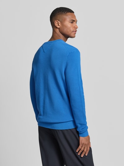 Männermodel trägt Regular Fit Strickpullover aus reiner Baumwolle van Tommy Hilfiger, effen, gebreide look, logodetail, lange mouw, ronde hals, rompzoom, puur katoen, Ganzkörperansicht Rückansicht.