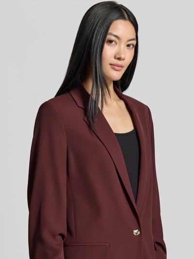 Frauenmodel trägt Oversized Blazer mit Raffungen von Jake*s Collection in Dunkelrot mit Reverskragen, Knopfverschluss, Nahaufnahme Oberkörper.