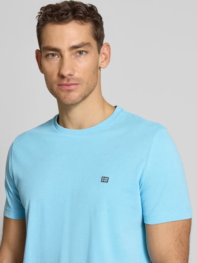Männermodel trägt T-Shirt aus Baumwolle mit Rundhalsausschnitt von Christian Berg Men in Hellblau, Regular-Fit, Label-Detail, Nahaufnahme Oberkörper. Rückenlänge bei Größe M: 71 cm.