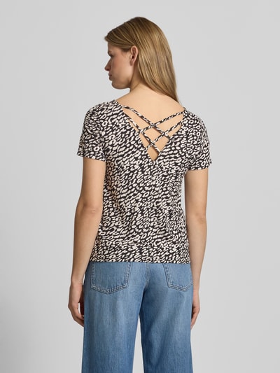 Modelka nosi Regular Fit T-Shirt aus Viskose-Mix Modell 'BERA' od Only, czarno-białe, wzór allover, krótki rękaw, detal sznurowany tył, materiał crêpe, widok całej sylwetki z tyłu.