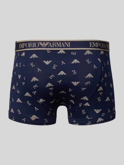 Männermodel trägt Trunks im 3er-Pack mit elastischem Logo-Bund von Emporio Armani, dunkelblau, Allover-Logo, Baumwoll-Mix, Ganzkörperansicht Rückansicht.
