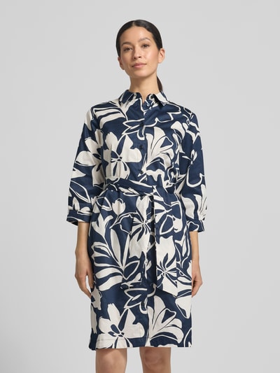 Modelka kobieca ma na sobie Regular Fit Midikleid mit floralem Allover-Print od Betty Barclay, niebiesko-biały wzór, len, kołnierz, półdługi rękaw, pasek w talii, zapięcie na guziki, krój regular fit, długość do kolan, całkowity przód.