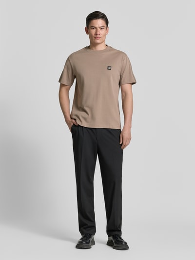 Männermodel trägt Relaxed Fit T-Shirt aus reiner Baumwolle Modell 'DROSTEE' von HUGO, Optik: Unifarben, Label-Patch, Rundhals, Kurzarm, Materialverarbeitung: Jersey, Ganzkörperansicht von vorne.