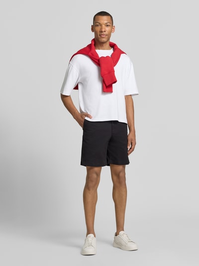 Männermodel trägt Chinoshorts aus Baumwoll-Mix Modell 'DOVER' von Tommy Hilfiger, Optik: Unifarben, Passform: Regular-Fit, Ganzkörperansicht von vorne.