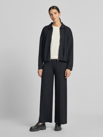 Frauenmodel trägt Wide Fit Hose mit Ziernähten von Christian Berg Woman aus elastischem Material-Mix, schwarze Farbe, Ganzkörperansicht von vorne