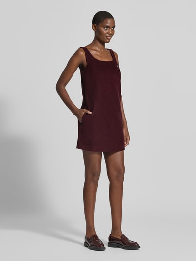 Vrouwenmodel draagt slim fit vrijetijdsjurk uit puur katoen van Lacoste in bordeauxrood, rechte vorm, gladde textuur, geheellichaamsvooraanzicht.