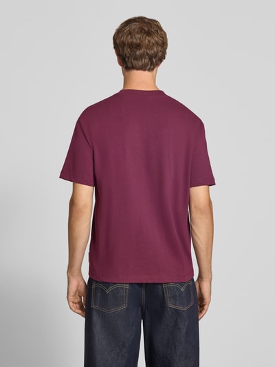 Männermodel trägt Relaxed Fit T-Shirt aus reiner Baumwolle von Marc O'Polo DENIM in Dunkelrot, glatte Struktur, Ganzkörperansicht Rückansicht.