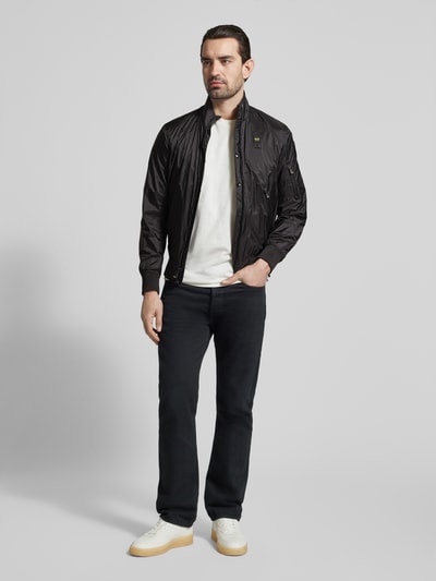 Männermodel trägt Jacke mit Reißverschlusstaschen Modell 'Brahms' von Blauer Usa in Schwarz, zweiwege-Reißverschluss, Ganzkörperansicht von vorne.