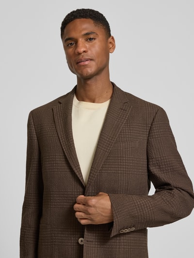 Männermodel trägt Slim Fit 2-Knopf-Sakko aus Leinen-Baumwoll-Mix von bugatti mit Strukturmuster, Reverskragen, Nahaufnahme Oberkörper. Rückenlänge 74 cm, Schulterbreite 46 cm, Ärmellänge 65 cm bei Größe 50.