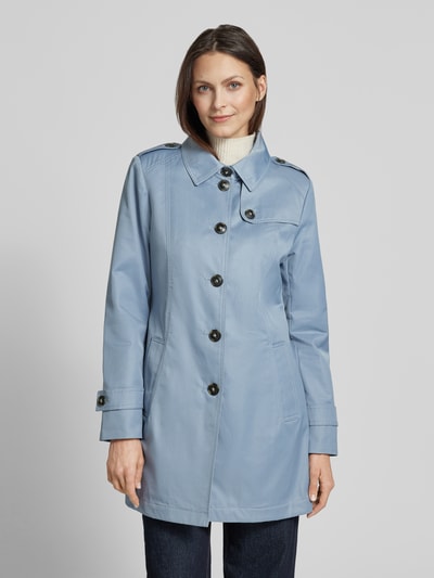 Frauenmodel trägt Trenchcoat mit Ärmelriegeln von Fuchs Schmitt in Hellblau, Umlegekragen, Knopfleiste, Eingrifftaschen, Ganzkörperansicht von vorne