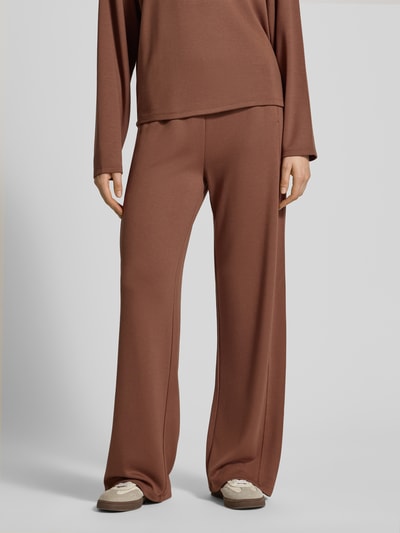 Frauenmodel trägt Regular Fit Sweatpants aus Viskose-Mix von s.Oliver RED LABEL in Braun mit elastischem Bund und seitlichen Taschen, Nahaufnahme Unterkörper.