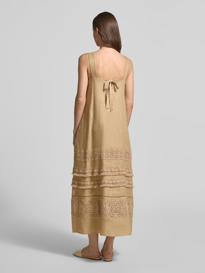 Männermodel trägt Fließendes Freizeitkleid aus reinem Leinen Modell 'DOLMEN' von Weekend Max Mara, beżowe, bez rękawów, z koronką, maxi długość, kieszenie boczne, luźny krój, tkanina lniana, widok całej sylwetki od tyłu.