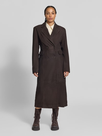 Frauenmodel trägt Ledermantel aus echtem Leder von ROTATE in Dunkelbraun, taillierte Passform, Doppelreiher, Klappentaschen, Ganzkörperansicht von vorne. Rückenlänge 129 cm, Brustweite 42 cm, Ärmellänge 66 cm, Ziegenvelours, Reverskragen.