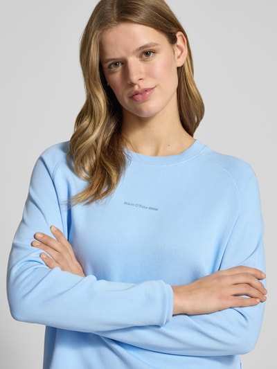 Vrouwenmodel draagt Regular Fit Sweatshirt uit pure katoen van Marc O'Polo Denim in effen lichtblauw, ronde hals, labeltekst, sweatstof. Close-up bovenlichaam.