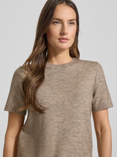 Frauenmodel trägt Kurzarm Strickpullover mit gerippten Abschlüssen Modell 'NEKKA' von Mango in Beige, Material-Mix mit Woll-Anteil, Regular Fit, Rundhalsausschnitt, kurzärmelig, Rückenlänge 48 cm, Ärmellänge 22 cm, Nahaufnahme Oberkörper.