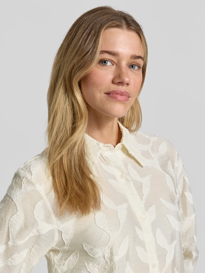 Frauenmodel trägt Bluse aus Viskose-Mix mit Strukturmuster Modell 'CRUZ' von Mango, Regular-Fit, Hemdblusenkragen, Knopfleiste, Nahaufnahme Oberkörper.