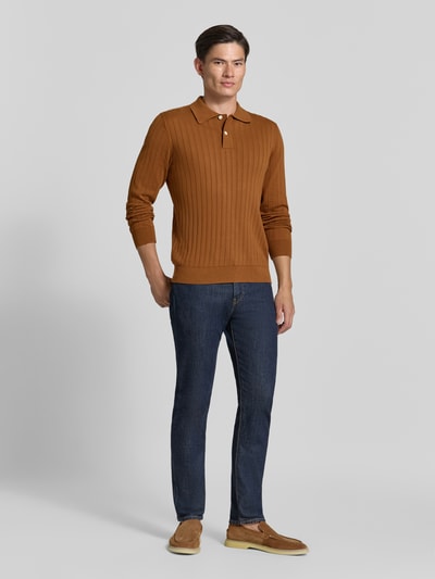 Männermodel trägt Regular Fit Poloshirt aus reiner Baumwolle Modell 'TORINO' von Selected in Braun mit gerippter Textur, Ganzkörperansicht von vorne.