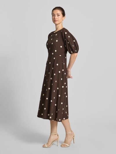 Frauenmodel trägt Midikleid aus Viskose-Mix im Allover-Look von Jake*s Casual in Braun mit weißen Punkten, A-Linie, Puffärmel, Ganzkörperansicht von vorne. Rückenlänge 116 cm, Brustweite 44 cm, Ärmellänge 35 cm, Viskose-Mix mit Baumwoll-Anteil.