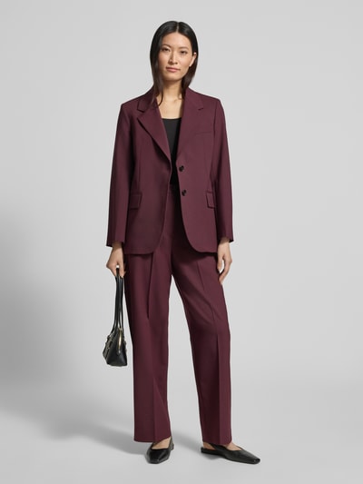 Vrouwenmodel draagt Loose Fit Weite Hose aus Woll-Mix van Tommy Hilfiger in effen bordeaux, twillstructuur, met persvouwen en logodetail, zijzakken en riemlussen, geheelvooraanzicht.