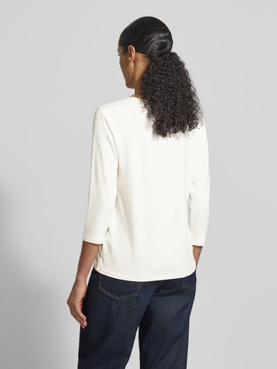 Frauenmodel trägt Regular Fit Longsleeve aus Viskose-Mix mit Ziersteinbesatz von monari in Creme mit 7/8-Arm und Rundhalsausschnitt, Rückenlänge bei Größe 36: 59 cm, Ganzkörperansicht Rückansicht.