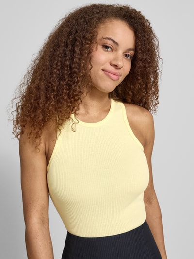 Frauenmodel trägt Slim Fit Tank Top aus Baumwoll-Mix Modell 'RUKA BOXER' von Pieces, unifarben, Rippstruktur, Rundhals, breite Träger, Nahaufnahme Oberkörper.
