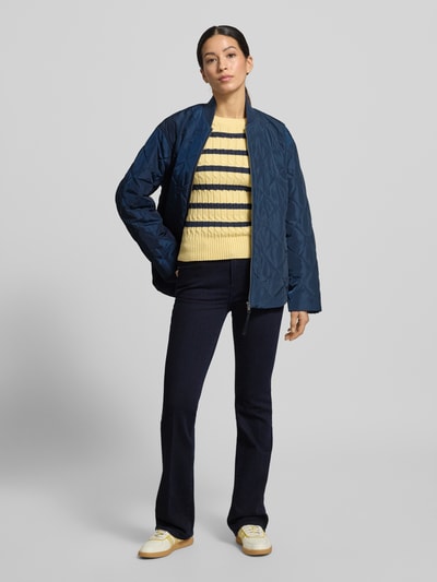 Frauenmodel trägt Regular Fit Bootcut Jeans aus Baumwoll-Mix von Tommy Hilfiger, dunkelblauer Melange-Denim, 5-Pocket-Design, Mid Waist, Ganzkörperansicht von vorne.