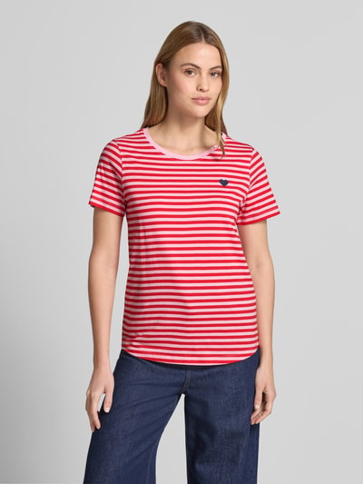 Frauenmodel trägt T-Shirt mit Motiv-Stitching und Rundhalsausschnitt von FREE/QUENT, rot-weiß gestreift aus Baumwolle, gerader Schnitt, Ganzkörperansicht von vorne.