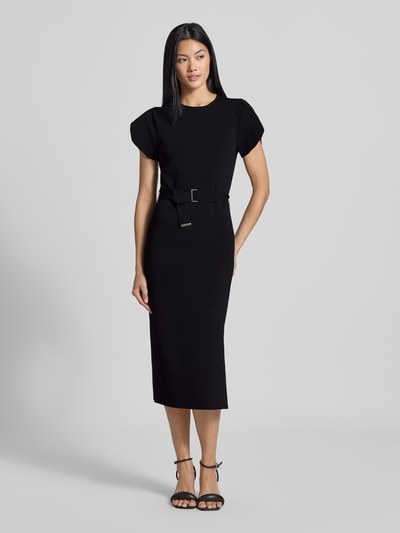 Vrouwenmodel draagt Slim Fit midi-jurk uit viscosemix Model 'JULIANY' van Ted Baker, effen zwart met riem, korte mouw, ronde hals, volledig frontaal zicht. Context: dames midi-jurk uit elastische viscosemix, slim fit, model 'JULIANY', ronde hals, ontwerp met korte mouwen, geïntegreerde riem, ruglengte maat 36: 110 cm, borstwijdte maat 36: 37 cm, mouwlengte maat 36: 14 cm.