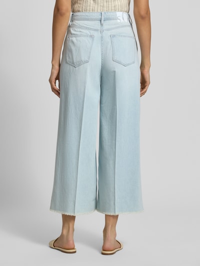 Kobiece modelka nosi Wide Leg Culotte-Jeans aus Lyocell-Baumwoll-Mix Modell 'SURI' od s.Oliver RED LABEL, denim, jasnoniebieski, pięć kieszeni, frędzle na dole, logo, szeroka nogawka, wysoki stan, z tyłu, widok całej sylwetki, kontekst: damskie culotte-jeans, lyocell-baumwoll-mix