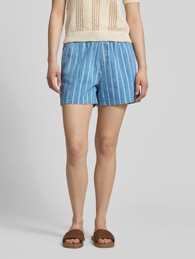 Vrouwenmodel draagt Relaxed Fit Jeansshorts uit puur katoen van Marc O'Polo Denim met gestreept denim design en elastische tailleband, cropped lengte, steekzakken en achterzak, materiaalstructuur duidelijk zichtbaar, volledig zicht van voren.