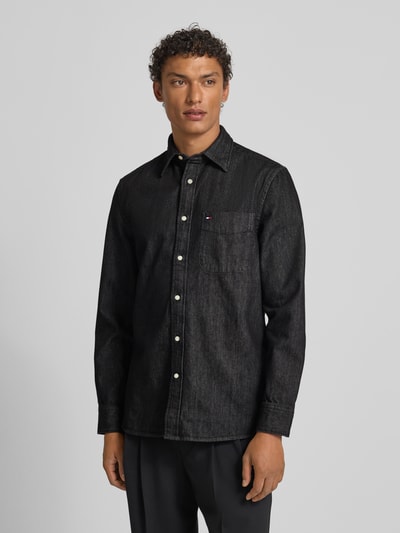 Männermodel trägt Regular Fit Jeanshemd aus reiner Baumwolle von Tommy Hilfiger in Black Denim-Optik, Ganzkörperansicht von vorne.
