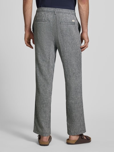 Männermodel trägt Hose aus Leinen-Baumwoll-Mix Modell 'MAXIM' von Blend in Grau mit feiner Struktur und elastischem Bund, Ganzkörperansicht Rückansicht. Relaxed Fit, Bundweite Größe M: 42 cm, Innenbeinlänge: 78 cm.