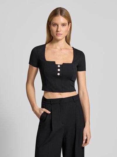 Vrouwenmodel draagt Cropped T-Shirt met Ziersteinbesatz Modell 'Evelina' van Guess in zwart, elastische mix, slim fit, cropped fit, voorkant, bovenlichaam close-up.