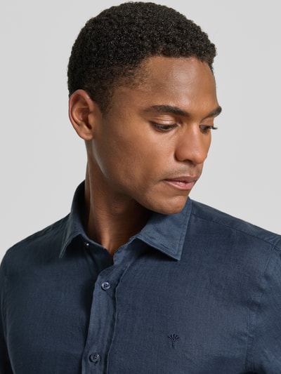 Männermodel trägt dunkelblaues Casual Fit Leinenhemd mit Kentkragen Modell 'Mike' von JOOP! Collection, Nahaufnahme Oberkörper. Reines Leinen, Knopfleiste, Sportmanschetten, abgerundeter Saum, Rückenlänge 73 cm, Schulterbreite 40 cm, Ärmellänge 66 cm.
